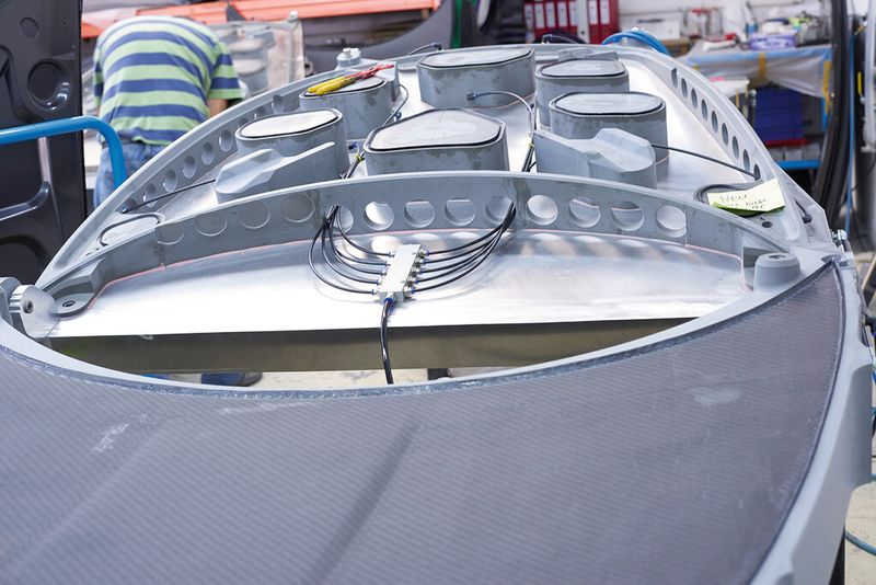 Das laminierte Carbon-Bauteil, hier der Kofferraumdeckel des Porsche GT3 RS, wird in einer Form vakuumiert und in der Autoklave unter Druck und Hitze gepresst. (Bild: DMG Mori)