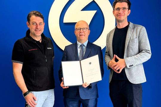 Michael Theurer, Parlamentarischer Staatssekretär beim BMDV (Mitte) überreicht die 1,3 Millionen Euro „schwere“ Förderurkunde an Steffen Bäuerle (CEO Globe Fuel Cell Systems, l.) und Dr. Bernhard Wienk-Borgert (Co-Founder und CTO bei Globe Fuel Cell Systems).(Bild:  Globe Fuel Cell Systems)