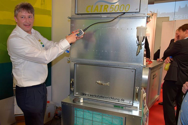 Michael Köberlein von KMWE zeigt die Wirksamkeit des Aktivkohlefilters in der Absauganlage Clair 5000. (Holz)