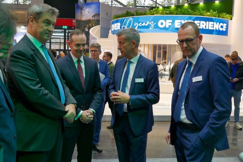 Die erste Station auf der Bauma war für die beiden Politiker der Stand von ZF. Andreas Moser (2. von rechts, Leiter der ZF-Division Nutzfahrzeugtechnik) und Daniel Härter (rechts, Leiter der Off-Highway-Sparte) informieren hier über neue elektrische Antriebe und dynamische Getriebe bei Baufahrzeugen.  (Bild: Sandro Kipar/VCG)