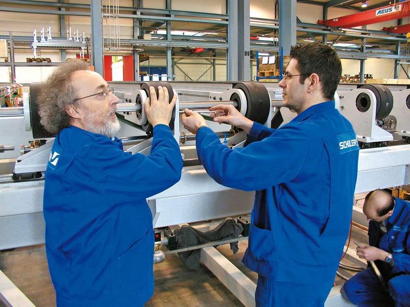 Bild 3: Schuler-Mitarbeiter bei der Montage der Transportbänder für den Platinenlader.Bild: Schuler (Archiv: Vogel Business Media)