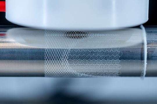 Der Prozess des Melt Electrowriting läuft ab. Das Besondere ist die bewegliche Auffangplatte, die einen feinen PCL-Schmelzestrahl in zuvor programmierte Bahnen zwingt. So entsteht etwa diese filigrane, netzartige Struktur. Der Prozess des Melt Electrowriting läuft ab. Das Besondere ist die bewegliche Auffangplatte, die einen feinen PCL-Schmelzestrahl in zuvor programmierte Bahnen zwingt. So entsteht etwa diese filigrane, netzartige Struktur.