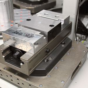 Der Doppelspanner D2 125 L-320 mit Mittelbacke glatt und Formbacken aus Aluminium ist auf einer Palette fixiert und wird mittels Nullpunkt-Raster-Systemplatte gredoc NRS 3-fach gespannt.(Bild:  Gressel AG)