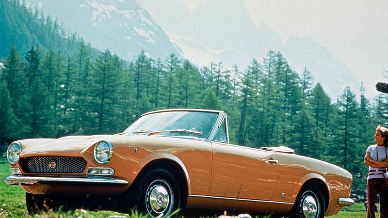 Sehnsucht nach südlicher Sonne: Als Sport Spider avancierte der Fiat 124 vor 60 Jahren zum schönsten Rivalen des Alfa Romeo Spider. Er wurde von 1966 bis 1982 von Fiat selbst und 1982 bis 1985 von Pininfarina im Auftrag von Fiat hergestellt, zu erkennen an dem unterschiedlichen Logo auf Kühlergrill, Lenkrad und Schaltknauf. Bis 1979 stieg die Motorleistung mit Einführung neuer Motoren mit 1,6 Liter Hubraum auf bis zu 110 PS (81 kW) an. Ab 1972 wurde der Spider auch mit 1,8-Liter-Motor angeboten, der 114 PS (84 kW) mit Vierganggetriebe und 118 PS (87 kW) mit Fünfganggetriebe leistete. Die ab Anfang 1978 produzierten Fahrzeuge wurden mit dem 2,0-Liter-Aggregat und mit bis zu 100 PS (74 kW) als Fiat 2000 Spider vermarktet. (Bild: Fiat)