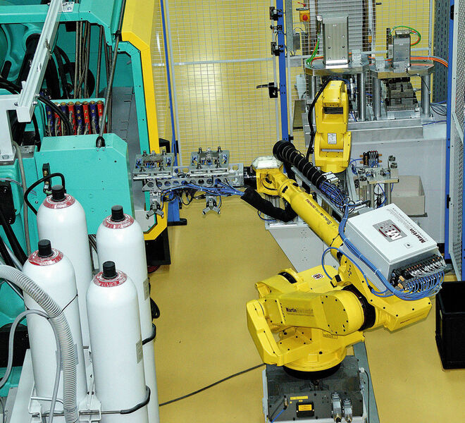 Während des Spritzgießvorgangs setzt der Roboter die fertig gespritzten Teile auf ein Umlaufsystem. In der nächsten Station werden die Pumpengehäuse geprüft und weiter zur Verpackung transportiert. (Bild: Kummer)