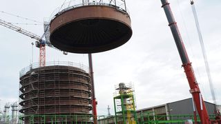 Der Jumbo schwebt direkt über seinem Ziel: 53 Tonnen schwer ist der neue Tankdeckel aus gummiertem Stahl. Er deckt den neuen Salzsäuretank im Dormagener Chemiepark ab. (Bild: Bayer)