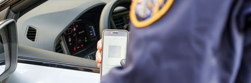 Ein Polizist scannt den generierten QR-Code