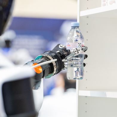 Ein humanoider Roboter entnimmt ein Getränk aus dem Regal. Die Demonstration auf der Bosch Connected World 2026 zeigte zentrale Fähigkeiten moderner Robotik in einem konkreten Handhabungsprozess. (Bild: Schunk SE & Co. KG)