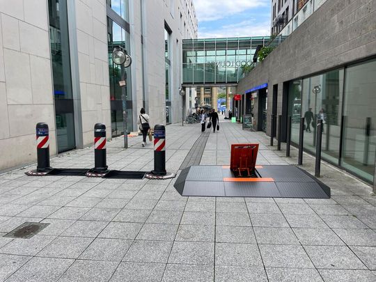 Links im Bild: drei Oktablocks von Hörmann in Stuttgart. Rechts ist der mobile Road Blocker M30 erkennbar, mit ausgeklapptem mittleren Sperrelement, damit Fußgänger und zum Beispiel Kinderwägen rechts und links leicht passieren können.(Bild:  Hörmann)