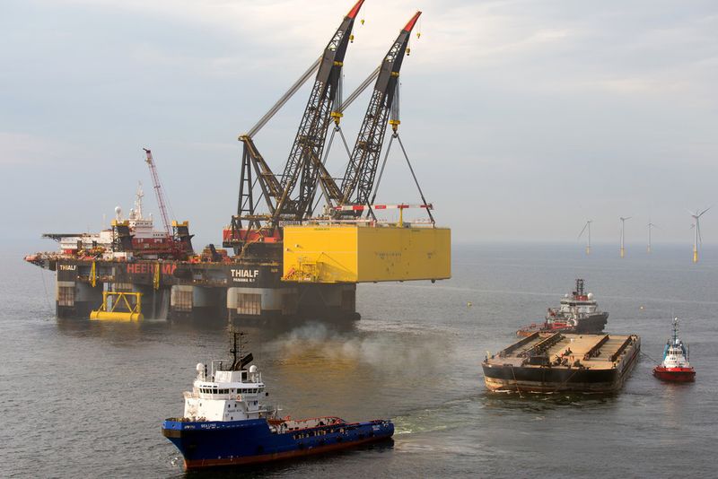 Mit dem Schwerlast-Kranschiff Thialf wird die Helwin2-Plattform von der Transport-Barge angehoben und dann auf die vorbereitete tragende Unterkonstruktion gehievt. (Ulrich Wirrwa, Siemens AG)