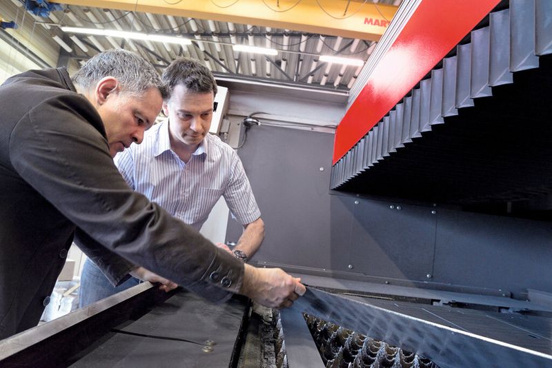 «Wir schauen, dass wir die Auftragsdaten von Herrn Borer schnell auf die Laserschneidanlage bekommen», Pascal Michel (hinten), hier zusammen mit Carlo Borer an der «Byspeed 3015». (Bild: Stephan Dürer)