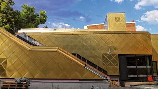 Das Passiv-Turnhalle entspricht den Frankfurter Anforderungen an nachhaltigen Sporthallenbau. Seine goldfarbene Fassade aus vollständig recycelbarem Kupfer gibt ihm eine warme Optik.  (Bild: Sperber Klempner)