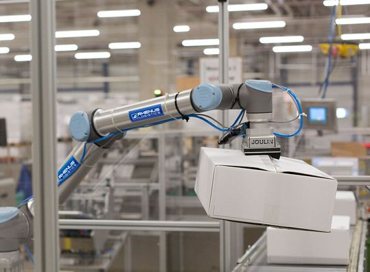 Ein Roboter von Universal Robots optimiert die lagerinternen Abläufe bei Rhenus Logistics in Gießen. Der Einsatz eines zweiten Cobots am Ende der Fertigungslinie wird diskutiert. Ein Roboter von Universal Robots optimiert die lagerinternen Abläufe bei Rhenus Logistics in Gießen. Der Einsatz eines zweiten Cobots am Ende der Fertigungslinie wird diskutiert.