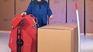 Das Umreifungssystem wird vor die Palette gerollt. Die Kettenlanze schiebt sich dann unter das Packgut, nimmt das Band mit und führt es dem Bediener wieder zu.  Bild: Ergopack (Archiv: Vogel Business Media)