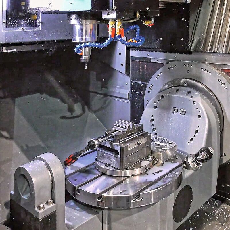 Working area of the 5-axis VC500i, showing the rotary table / swivelling trunnion positioned from front-to-back, instead of in the more usual side-to-side arrangement. Doors on two sides open to allow ergonomic operator access.