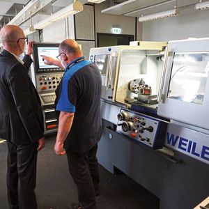 Christian Fuchs, Weiler, und Ausbilder Matthias Manthey an der zyklengesteuerten Präzisions-Drehmaschine Weiler E30.(Bild:  Siemens Mobility GmbH)