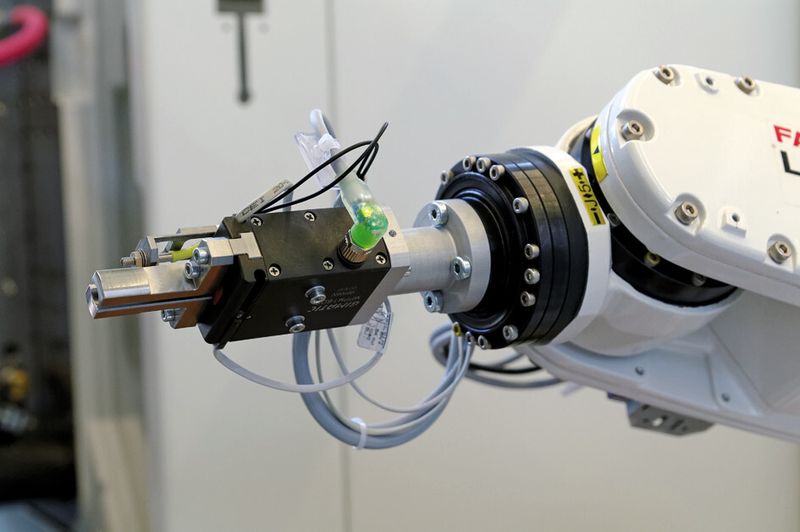 Bild 2: An der Schnittstelle von der Maschine zur Palettiereinrichtung sortiert ein kleiner Knickarmroboter mit dem Parallelgreifer die Kunststoffteile. (Bild: Gimatic)