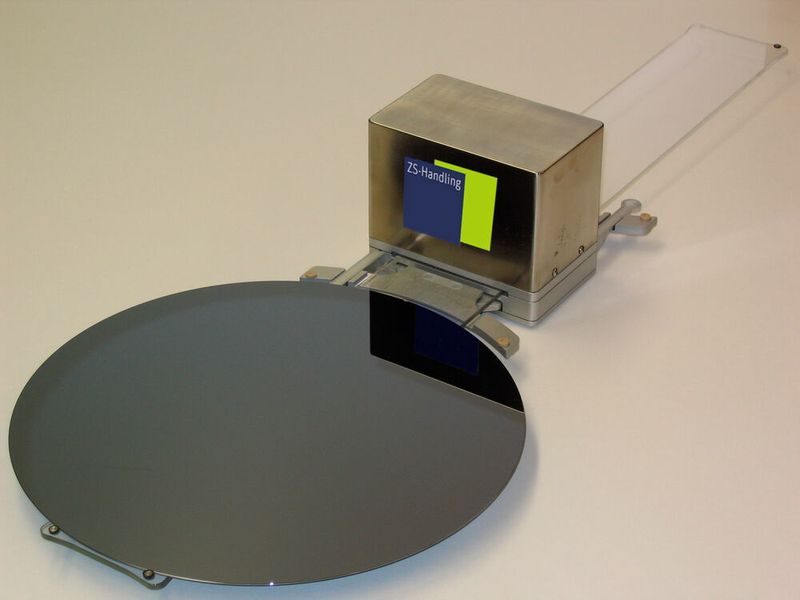 Die Lösung von ZS-Handling umfasst die komplette Roboterzelle und enthält das Waferhandlingssystem LeviWafer Greifer in der Ausführung als Double Paddel, das mit beliebigen Robotersystemen verbunden werden kann. (ZS-Handling)