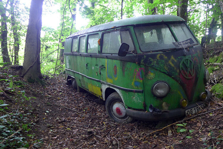 In einer tiefen Waldkuhle steht einsam ein VW Bulli. (Foto: SP-X)
