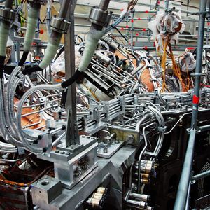 Wendelstein 7-X – Das Bild zeigt einen Ausschnitt eines Magnetmoduls mit installierten Busleitern: Die bis zu 14 Meter langen Leiter mussten einzeln in ihre komplexe Form gebracht werden, bevor sie ihre Isolierschicht erhielten.