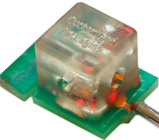 So geht Mikroverpacken: Elektro-optisch-fluidischer Demonstrator mit eingebetteter LED im 3D-Gehäuse und Mikrofluidikkanälen. Alles ist als Gesamtkomponente auf eine Leiterplatte gelötet. (Bild:  Micropack3D)