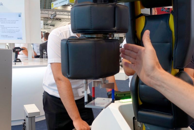 Nach der Beschriftung übergibt der Cobot die Platte wieder an den Handarbeitsplatz. Schon bevor er den Werker berührt, stoppt der Cobot seine Bewegung. (Stefanie Michel)