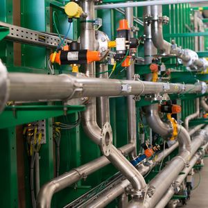 Rohrleitungssysteme verbinden die Fermentercontainer mit der Technikzentrale. Der Rohrgang wird vor der Inbetriebnahme noch baulich geschlossen.