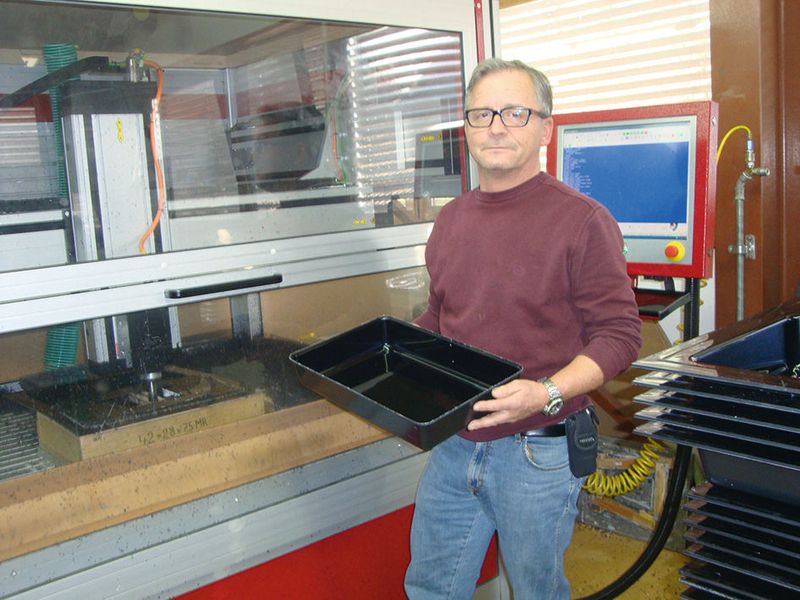 Ruedi Kirchhofer vor einer der drei Isel-CNC-Overhead-Maschinen mit einer Schale für Metzgereien. (Bild: Flexor)