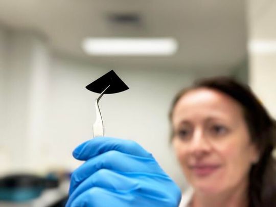 Dr Natalie Borg inspects a sample of the nano spiked silicon sheet.(Source:  RMIT)