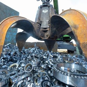 Wälzlager verschiedenster Bauarten und Größe werden vom Greifarm des Baggers unter lautem Getöse in die Schrottpresse befördert.