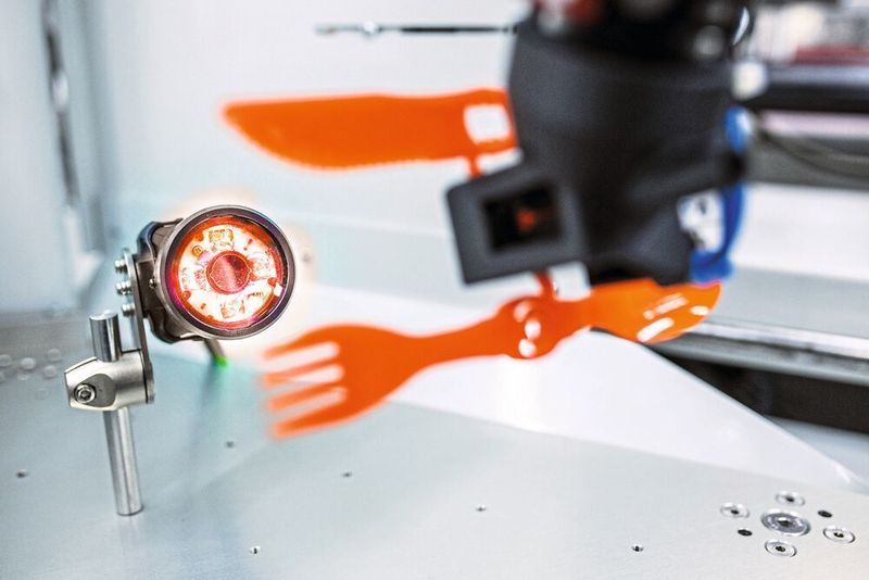 Der Kuka Roboter legt das frisch aus der Spritzgussmaschine kommende Bauteil zum Abkühlen ab. (Kuka)