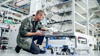 Ein Mitarbeiter von Engelbert Strauss begutachtet einen Schuh vor einem Schuhrondel in der CI Factory in Schlüchtern. (Bild: engelbert strauss GmbH & Co. KG)