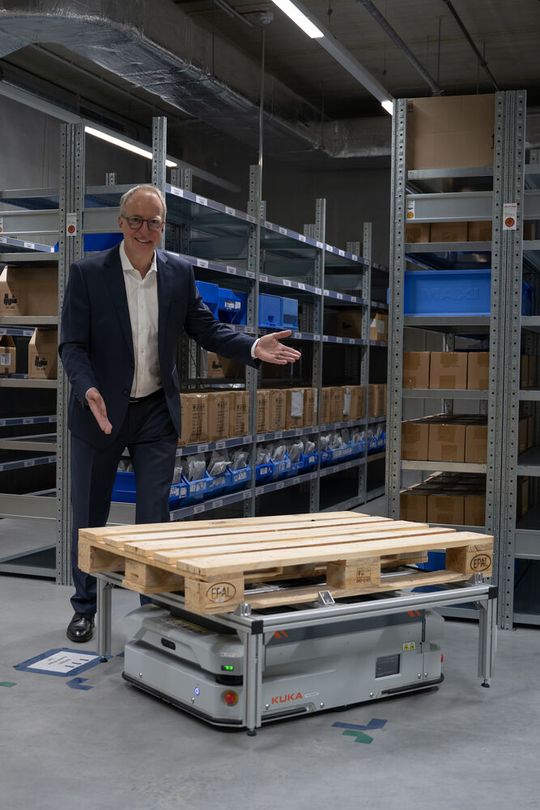 Steffen Ebner mit dem Kuka KMP-600P, der in Eigenanwendung im Bereich der Komsa Logistik im Einsatz ist(Bild:  Komsa)