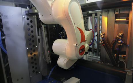 Le robot à bras articulé suspendu au plafond et intégré dans une machine standard d’injection prélève et traite des capuchons de fermeture de poches de transfusion dans un espace étroit. (Image Kuka) (Archiv: Vogel Business Media)