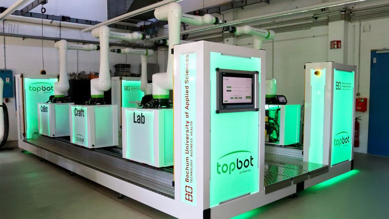 Die grüne Beleuchtung zeigt, dass die Roboter einsatzbereit sind und alles sicher ist. Sobald jemand zu nah an einem der Roboterarme steht, schaltet die Beleuchtung auf rot und die Roboter stoppen.(Bild:  Judith Merkelt-Jedamzik, HSBO)