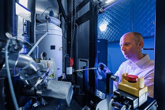 ORNL’s David Cullen stands in front of the new Thermo Scientific Spectra Ultra transmission electron microscope.  (Source: ORNL/ Carlos Jones, U.S. Dept. of Energy)