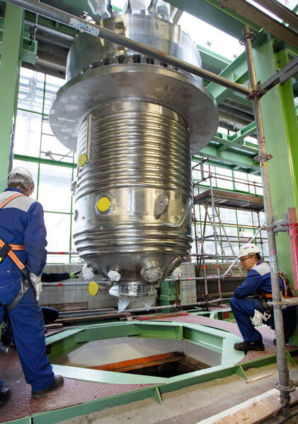 Projektleiter Peter Rudolph und Construction Manager Peter Schumacher beobachten, wie der maßgefertigte Reaktor ins Zentrum der CO2-Produktionsstraße einschwebt. (Bild: Bayer Material Science)