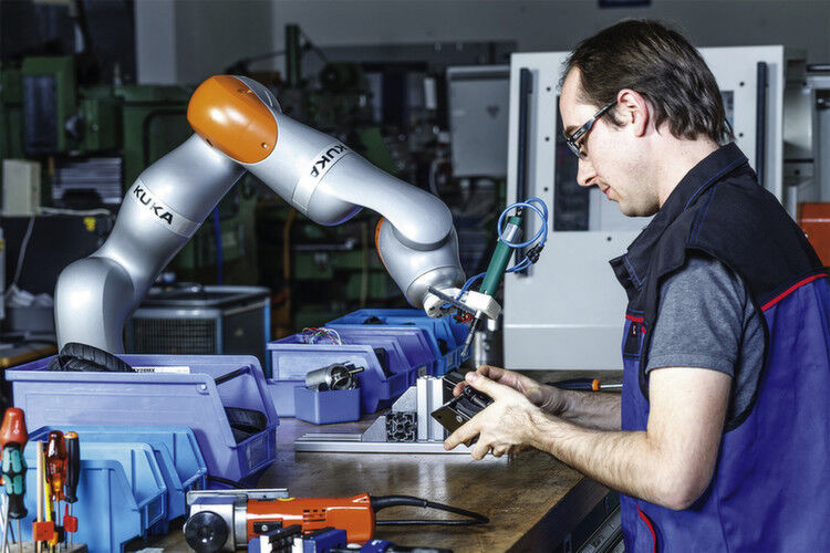 Einst Gegner, jetzt Kollegen: Ein Monteur arbeitet mit einem Kuka-Leichtbauroboter Hand in Hand. (Bild: Kuka)