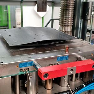 So sieht es aus, wenn die aufgewärmten Organobleche für das Leichtbau-Sandwich-Teil vom Robotergreifer ins Spritzgießwerkzeug platziert werden. Die Spritzgießmaschine selbst stammt von Engel Austria.(Bild:  Fraunhofer IMWS)