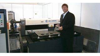 Krisha Bogacki, Leiter Automatisierung und Vertrieb, vor der CNC-Laserschneidmaschine Eco von HEL, die laut Angaben ohne Schutzumhausung betrieben werden darf. (Bild: Königsreuther)