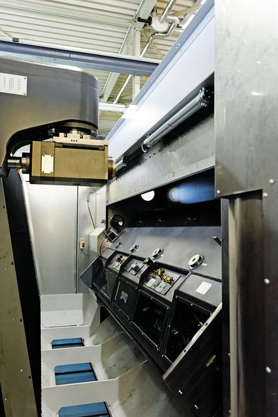 Sehr steife Fahrständerkinematik mit kurzen Ausgleichswegen. Der Schwenktisch (hier in Bewegung) arretiert in der 0°-, respektive 180°-Position, so dass alle Späne und Materialreste direkt auf den Spanförderer fallen, ohne Nester bilden zu können. Der Feinstaub wird aus dem gesamten, sehr kompakten, komplett gekapselten Arbeitsraum strömungstechnisch optimiert nach oben abgesaugt. (Bild: Marschner)