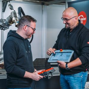 Umetec-Fertigungsleiter Tony Meyer (links) lässt sich vom Fronius-Anwendugstechniker Andreas Plumeier demonstrieren, wie man die Fronius-Smartcell teachen kann. Das klappe mit der Software Smartarc und dem Saep-Handgriff komfortabel und einfach.(Bild:  Chr. Große pivopix / Fronius)