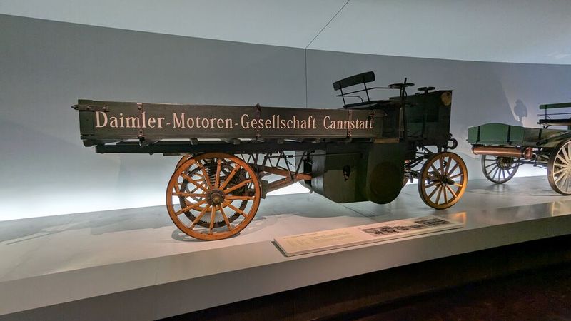Der Daimler Motor-Lastwagen (1896) der Daimler-Motoren-Gesellschaft war der erste Lastkraftwagen der Welt. Der Motor leistete 4 PS (2,9 kW) bei einer Drehzahl von 700 U/min und war  mit einer Glührohrzündung und Spritzdüsenvergaser ausgerüstet. Er war beim ersten Prototyp noch hinter der Hinterachse eingebaut und trieb die Hinterräder über ein Viergang-Riemengetriebe an. Das Fahrzeug war 4,5 m lang und 1,5 m breit, die Nutzlast wurde mit 1500 kg und das Leergewicht mit 1500 kg angegeben, die Höchstgeschwindigkeit betrug 12 km/h. (Bild: Dominsky – VCG)