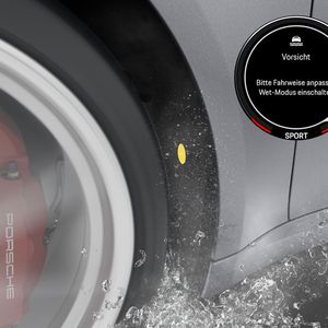 Eine Einblendung im Cockpit (hier im Bild rechts oben eingefügt) informiert den Fahrer über einen kritischen Straßenzustand. Das Programm begrenzt aber weder die maximale Leistung des Motors noch schränkt es die Höchstgeschwindigkeit ein. (Bild:  Porsche)