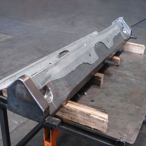 Der L-förmige Crashträger springt sowohl in Längsrichtung als auch in Schenkelrichtung auf.