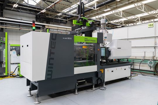 Das ist die vollelektrische Spritzgießmaschine Wintec e-win 1800 mit der Engel im Rahmen einer Fertigungszelle auf der Fakuma zeigt, wie man die Massenfertigung von Standardbauteilen, wie Stecker oder Kabelbinder trotz Konkurrenzdruck wirtschaftlich ablaufen lassen kann.(Bild:  Engel)