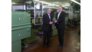 Weihten die neue Hightech-Produktionsanlage für Kunststofffäden ein: Frank Winkes, Geschäftsführer von Perlon-Monofil (rechts), einer Tochter des Spezialchemie-Konzerns Lanxess, übergibt Jürgen Büdenbender, Leiter Forschung und Entwicklung bei Perlon-Monofil, vor der neuen Maschine symbolisch das Modell eines Reckwerks. (Bild: Lanxess)