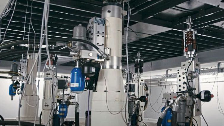 ...zeigt ein Blick unter diesen, welche Technik hier verbaut ist. Um ein Fahrzeug in Schwingung zu versetzen, bewegen sich vier Podeste vertikal. Durch diese Auf-und-Ab-Bewegungen federn die Räder ein und aus, wodurch das Fahren auf einer Straße simuliert und analysiert wird. (Bild: KW Automotive)