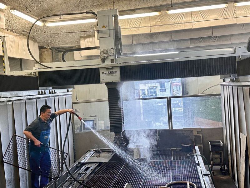 La fumée que l'on voit est de la poussière d'abrasifs, l'environnement de travail est impressionnant dans la zone de découpe de grosses pièces chez Waterjet. (Source : MSM)