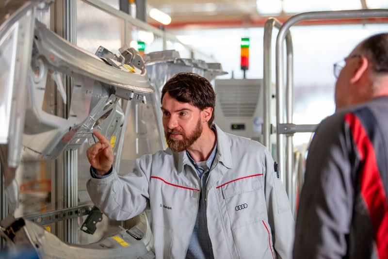 Ein Audi-Fachmann begutachtet eine mit Acerios von Fronius gereinigte Stelle an einem Aluminumkarosserieteil. (Fronius)